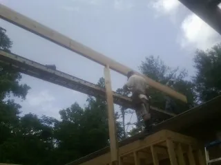 Carpenter setting a ridge beam over a new addition frame — Ice Dam Removal by Roofing Brothers in Cataldo