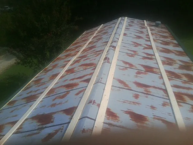 Rusted metal roof panels with new wood purlins before replacement — Storm Damage Roof Repair in Cataldo by Roofing Brothers