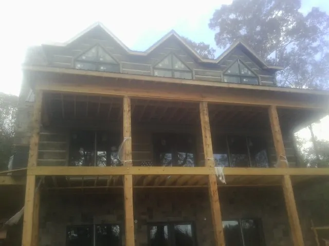 Dormers and porch framing on a large log home under construction — Roof Coating work by our crew in Cataldo