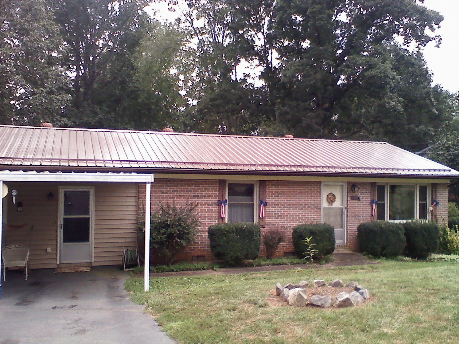 Bronze metal roof and carport on a brick ranch home — Roof Repair work by our crew in Cataldo